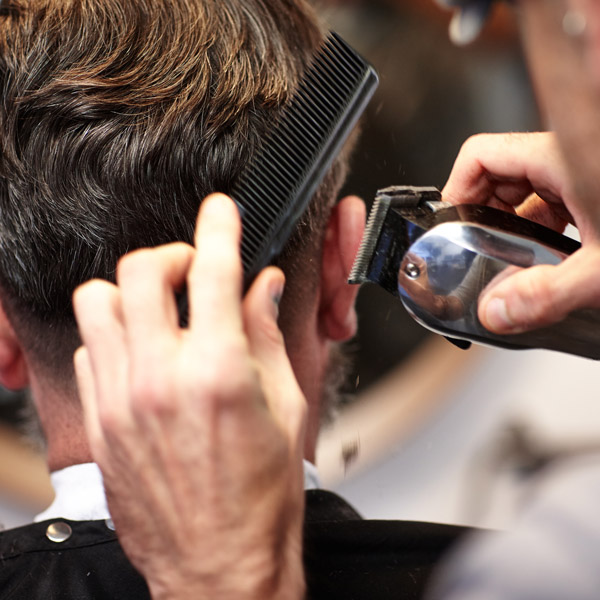 man cutting guy's hair
